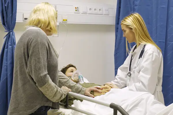 female doctor assessing and reassuring patient and mother